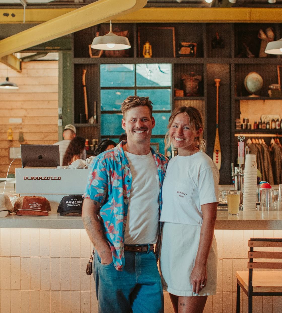 Two cafe owners smiling in front of their shop