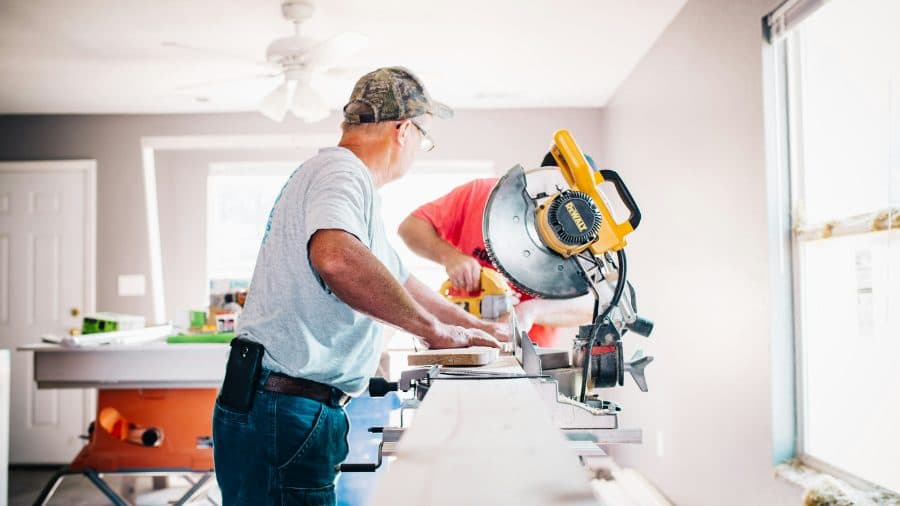 A tradesperson operating a drop saw on a residential build